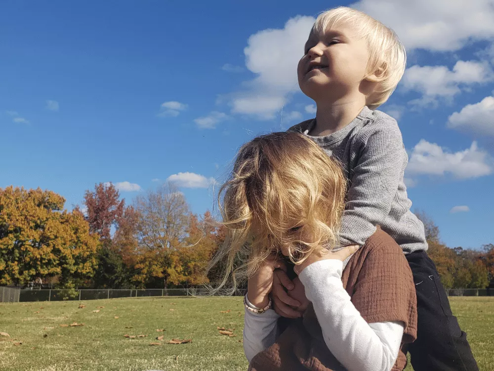Two children playing together outdoors during a family childhood moment