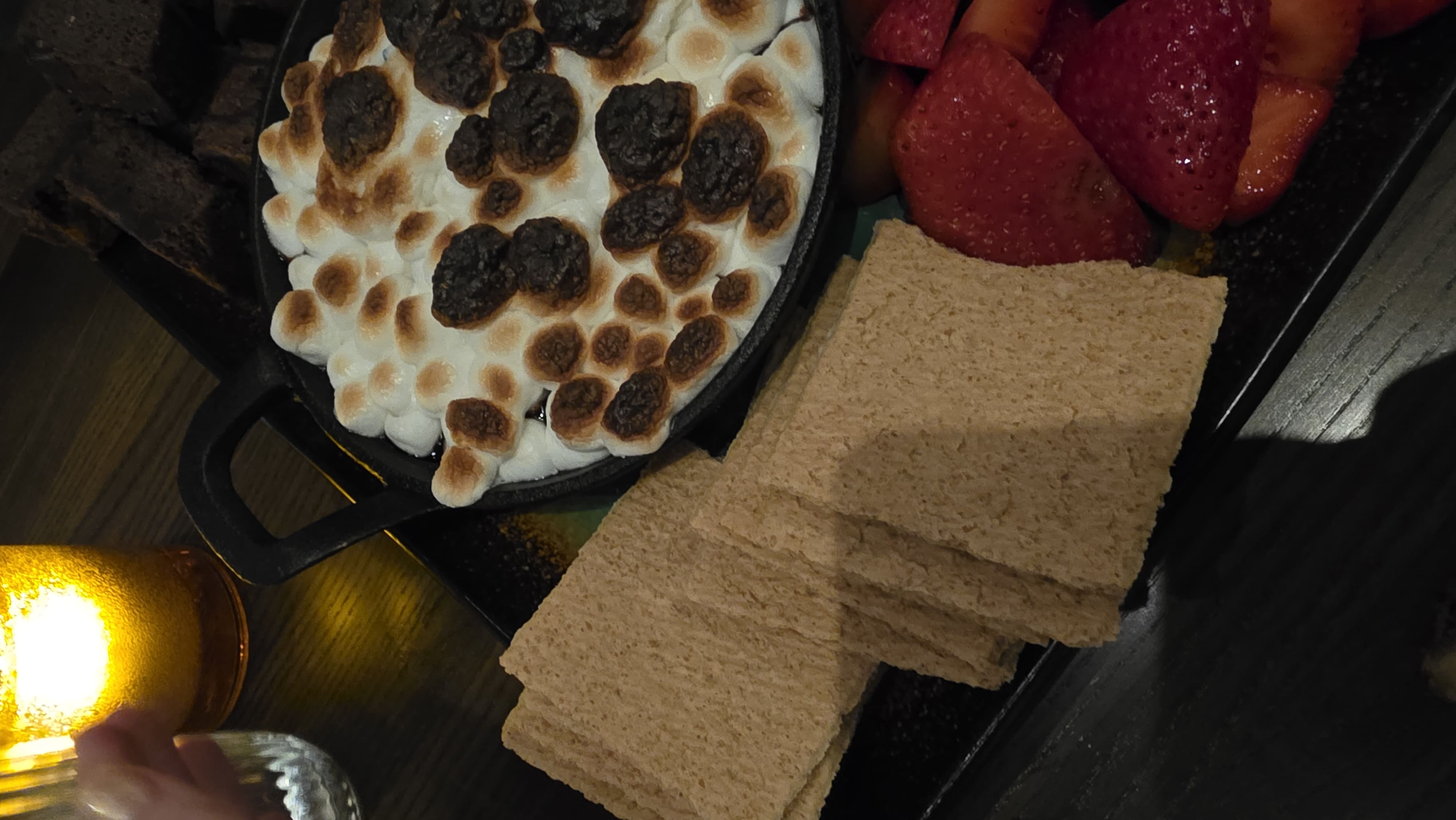 Roasted marshmallows, graham crackers, and fruit prepared for a family dessert