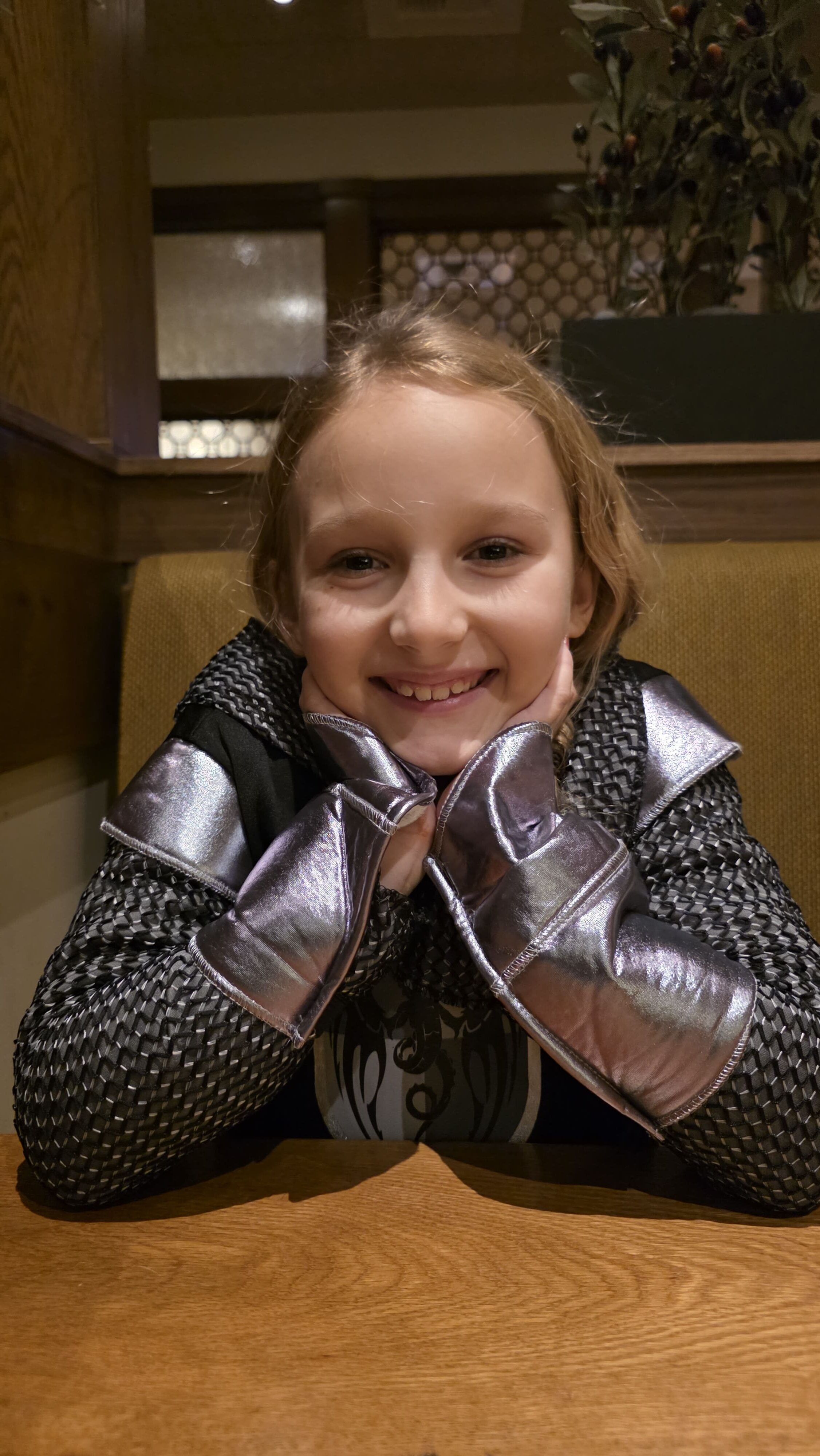 Smiling child wearing an October costume during a family evening out