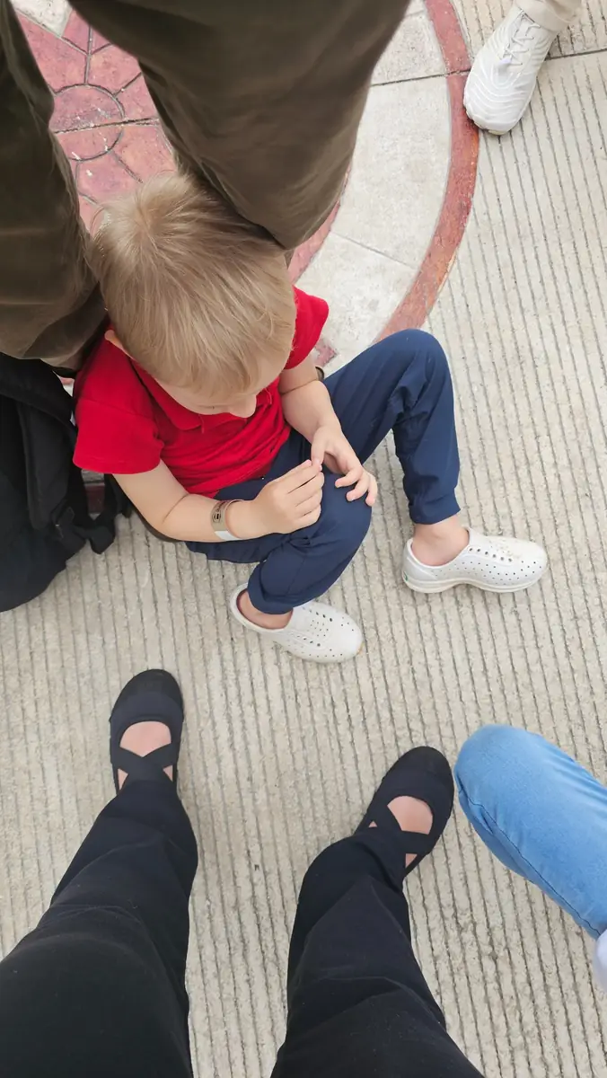 Child sitting outside wearing shoes during a family outing